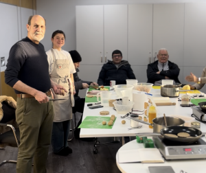 Four men and one of our chefs are chopping dough in a classroom