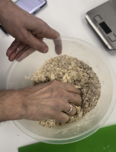 Two male hands mixing dough in a bowl 