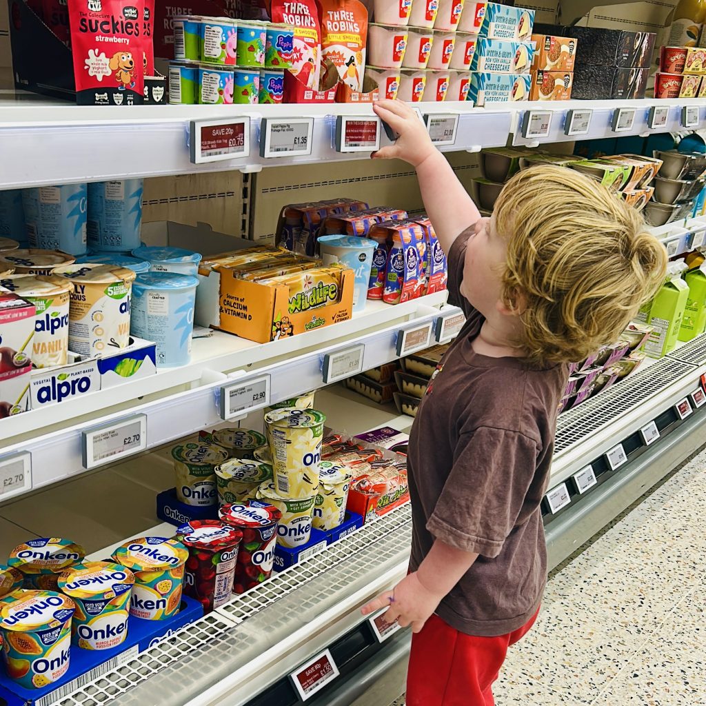 Small child reaching for yoghurt